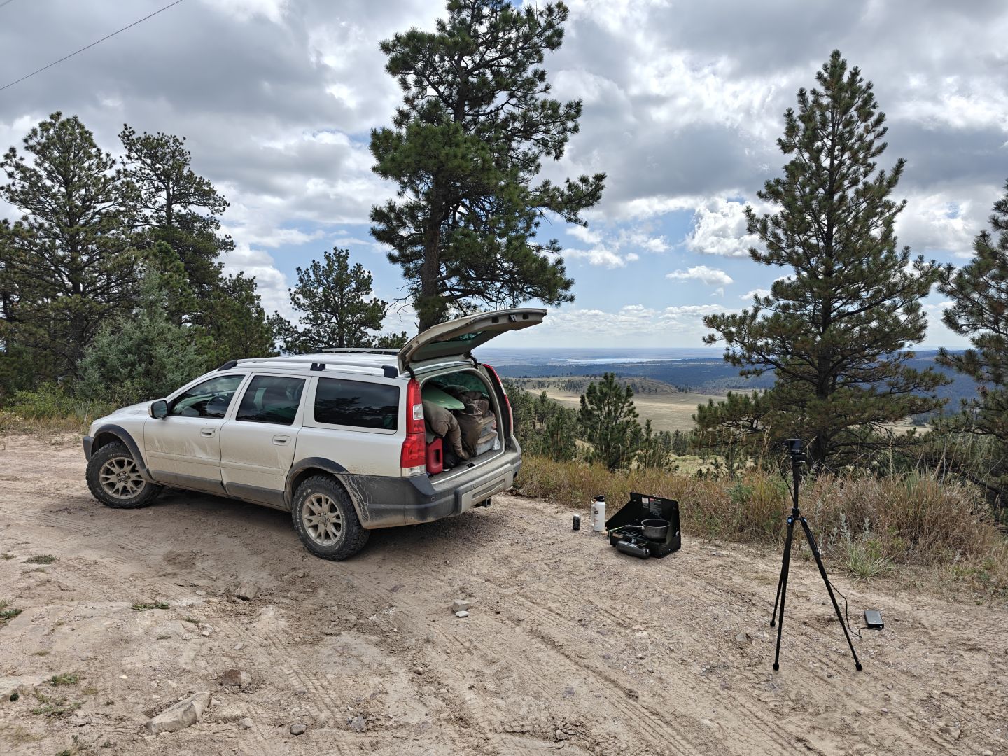 Volvo XC70 at the edge of a cliff with a view of plains and a lake in the distant background